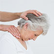 chiropractor helping stretch an elderly patient's neck