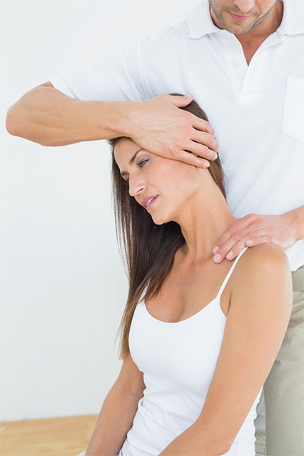 chiropractor helping stretch a patient's neck, pain management
