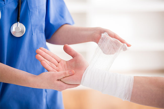 medical professional wrapping a patient's wrist in gauze