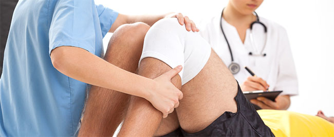 medical professionals examining a patient with a knee injury